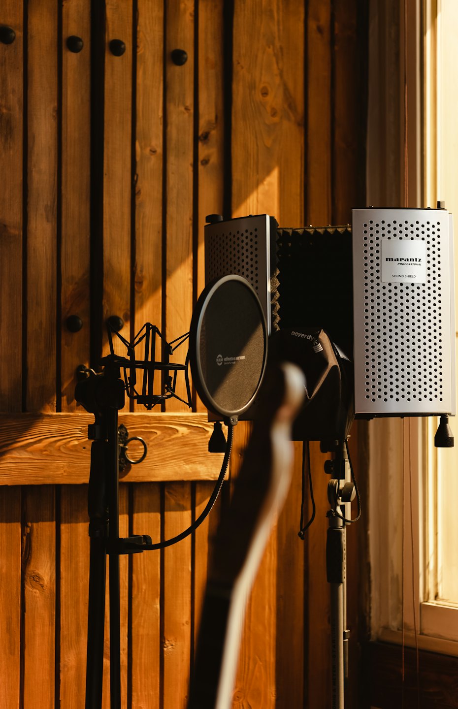 Micrófono profesional y pantalla acústica en un estudio de grabación.